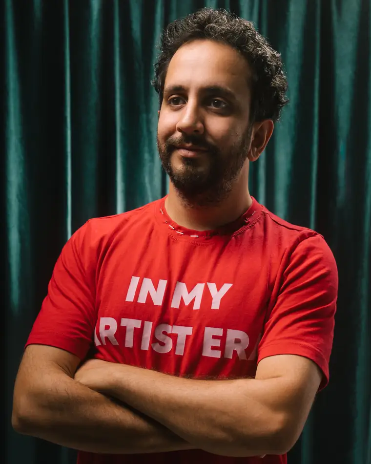 Portrait of Ediz Akatlar against a green velvet curtain.