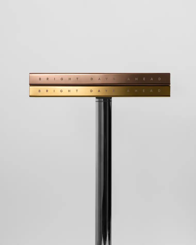Notebooks with brass and copper edges mounted on a chrome stand.
