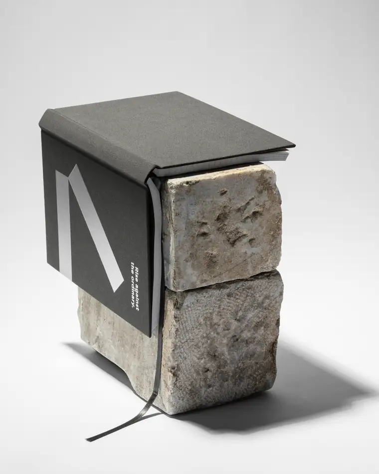 The same notebook seen from behind, wedged between two blocks of stone.