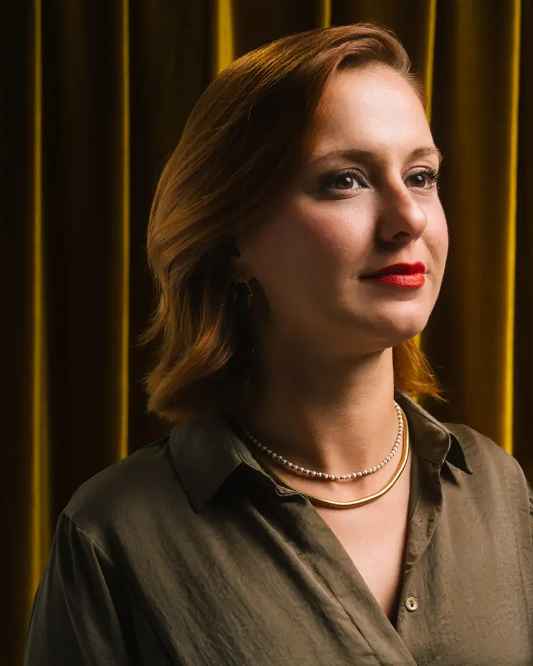 Portrait of Hilal Dadaş against a gold curtain.