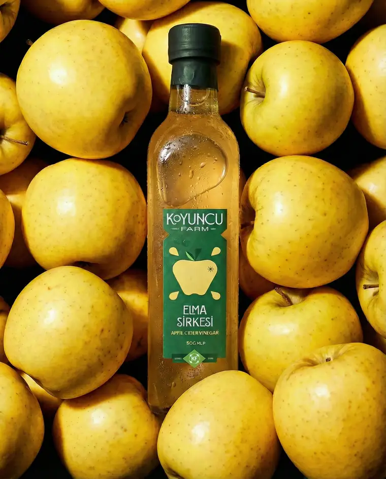 Vinegar bottle lying in a dense bed of golden apples.