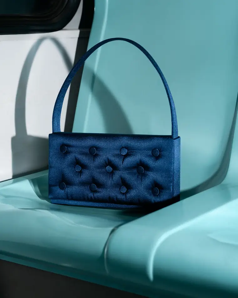 Navy quilted bag on a mint green ferry seat.